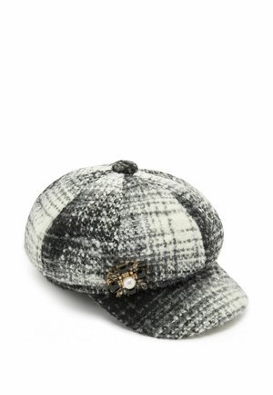 Cappello di lana a quadri in bianco e nero con forma arrotondata. Presenta una spilla decorativa con una perla e pietre nere ai lati.