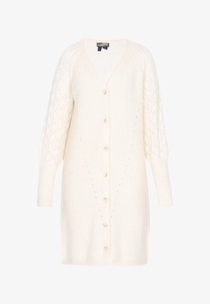 Valge kootud kardigan V-dekolteega, pikkade varrukatega ja nööbiga ees. Omab tekstuurset mustrit varrukatel ning lahti istuvat lõiget.