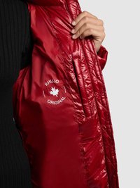 Rode gewatteerde jas met een glanzende afwerking, doorgestikte textuur en een logo met een esdoornblad op de binnenvoering. Zwarte geribbelde bovenkant zichtbaar.