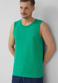 Grünes, ärmelloses Tanktop aus Baumwolle mit rundem Halsausschnitt und dezentem Markenlogo auf der Brust. Strukturierter, leichter Stoff.
