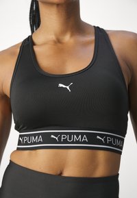Puma KEEPS BRA - Športni modrček s srednjo podporo - black