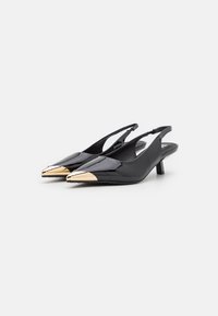 Chaussures slingback en cuir verni noir avec un bout pointu, une accent en métal doré et un petit talon. Texture lisse et design épuré.
