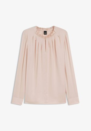 Lyserød bluse lavet af blødt stof, med rund hals, plisseret frontdesign og lange ærmer med manchetter.