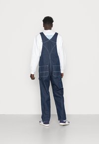 Carhartt WIP BIB OVERALL - Laisvo kirpimo džinsai - blue one wash