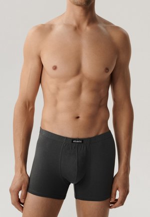 Czarne szorty bokserskie z elastycznym pasem z logo "ATLANTIC", wykonane z miękkiego materiału, noszone przez modela o umięśnionej sylwetce.