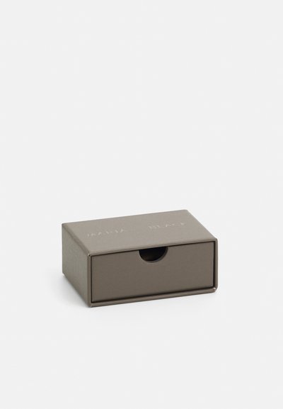 Rechthoekige cadeauverpakking van matbruin karton met een kleine ronde uitsnijding voor eenvoudig openen. Bevat een reliëf merknaam op het deksel.