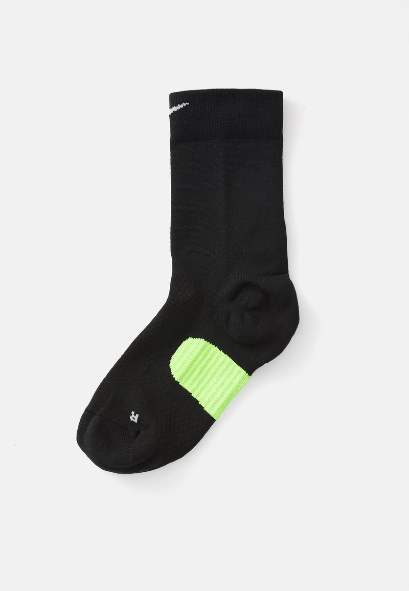 Zwarte sportsocken met een gestructureerd oppervlak, voorzien van een felgroene accent bij de hiel en een wit logo nabij de boord.