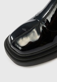 Crna gležnjača od lakirane kože sa četvrtastim vrhom, detaljem sašivenog šava i teksturiranom crnom gumenom đonom.