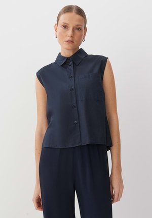 Camicetta senza maniche di colore navy con abbottonatura frontale, colletto, taschino sul petto e vestibilità comoda. Tessuto liscio con leggero lucido.