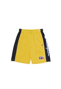 Pantalones cortos deportivos amarillos con paneles laterales de malla negra, cintura elástica y un logotipo blanco prominente. Incluye una etiqueta de tela en el frente.