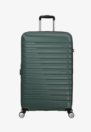 Hard-shell suitcase in dark green, featuring a textured ribbed design, telescopic handle, and four black spinner wheels.