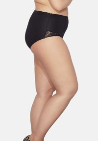 Höga svarta trosor i slätt tyg, med en spetsdetalj på sidan och en vågig midja för en dekorativ touch.