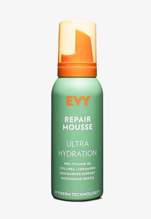 Grüne zylindrische Flasche mit orangem Pumpenkappen, beschriftet mit "Evy Repair Mousse Ultra Hydration", enthält Details zu Inhaltsstoffen und Technologie.