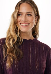 Maglione lavorato a maglia di un viola scuro con scollatura a balze, caratterizzato da un motivo testurizzato di strisce verticali e dettagli a traforo.