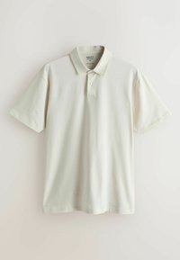 Polo homme blanc cassé à manches courtes avec col classique et patte à deux boutons, présenté à plat sur un fond neutre.