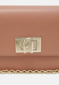 Borsa a tracolla in pelle marrone con una finitura testurizzata, hardware dorato e una tracolla a catena. Presenta una chiusura sicura con un design circolare.