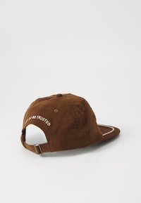 Brown corduroy cap with a curved brim, adjustable back strap, and white embroidered text reading "NOT TO BE TRUSTED" on the back.
