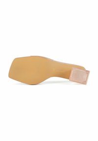 Prozirna potplat visokih potpetica s bež gumenom podlogom, s rebrastom teksturom i četvrtastim kapom pete s utisnutim detaljima na površini.