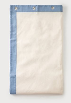 Rideau de douche crème plié avec bordure bleu clair et trois œillets métalliques le long du bord supérieur sur fond blanc.
