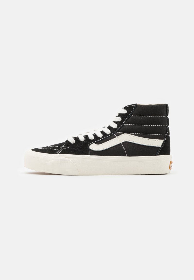 Zapatillas altas negras de ante y lona, con acentos blancos, cordones planos y una suela texturizada con una etiqueta de logo distintivo.