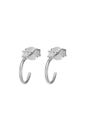 Paire de boucles d'oreilles créoles en argent avec un petit diamant clair rond en clou et des fermoirs papillon, présentées sur un fond blanc.