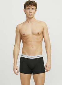 Schwarze Boxer Shorts mit einem weißen elastischen Bund, auf dem das Logo "Originals Studio" prangt, hergestellt aus einem glatten, dehnbaren Stoff.