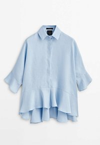 Blouse en lin bleu clair avec un devant boutonné, un col et des manches courtes ornées d'un détail à volants à l'ourlet, offrant une silhouette décontractée.