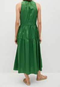 Zielona, bezrękawnikowa sukienka midi z marszczoną talią, o gładkiej fakturze i płynnej sylwetce, zaprojektowana z myślą o luźnym kroju.
