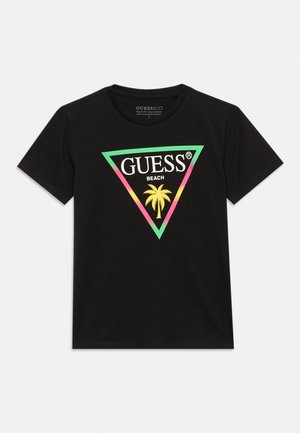 Črna kratka majica s pisanim trikotnim logotipom, v katerem je palmovo drevo, in napisom "GUESS BEACH" na sprednji sredini.
