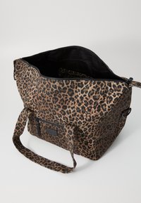 Bolsa de estampado de leopardo feita de tecido texturizado com fecho de correr, forro preto, alça longa e bolso exterior adicional com fecho de correr.
