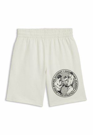 Pantaloni corti color crema con elastiche in vita, caratterizzati da una grafica nera di due pugili e il testo "Hugo Boxing Academy 1993 Athletics" sulla gamba.