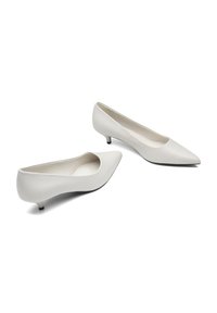 White leather pointed-toe pumps with a low heel. Smooth texture, minimal design, and a cut-out top line for comfort and ease of wear.