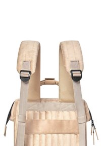 Beiger Rucksack mit samtiger Textur. Gepolsterte, verstellbare Riemen und detaillierte Nähte. Mit einem oberen Griff und Reißverschlussakzenten.