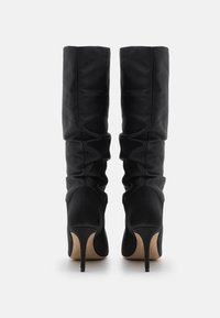 Black knee-high boots made of smooth leather with a ruched design, stiletto heels, and pointed toes.