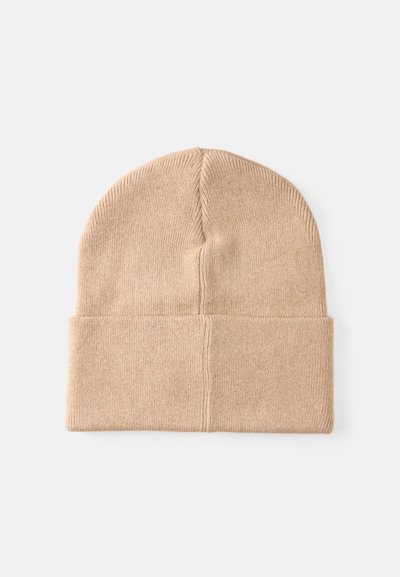 Gorro de malha bege com um punho dobrado, feito de um tecido suave e texturizado. Apresenta um topo sem emendas e uma forma ajustada e confortável.