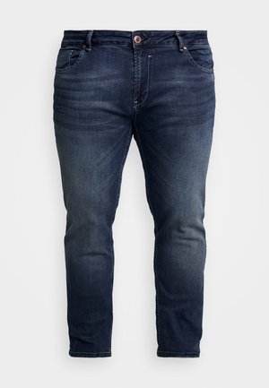 Dark blue denim jeans with a slim fit, featuring a zip fly, five pockets, and subtle fading on the thighs. Classic stitching detail.