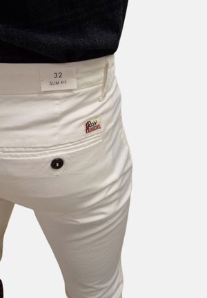 Pantaloni bianchi slim-fit con una tasca posteriore applicata, dotati di un bottone nero e un piccolo logo del marchio rosso e verde sulla tasca. L'etichetta riporta "32 SLIM FIT."
