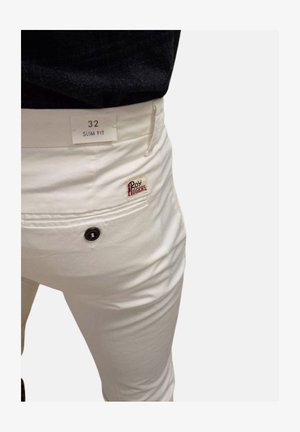 Pantaloni bianchi slim-fit con una tasca posteriore applicata, dotati di un bottone nero e un piccolo logo del marchio rosso e verde sulla tasca. L'etichetta riporta "32 SLIM FIT."