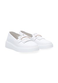 Witte instapschoenen van glad materiaal met een decoratieve franjes en metalen accent aan de voorkant, voorzien van een gestructureerde rubberen zool.