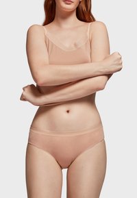 Lichtgewicht naakt camisol met dunne bandjes en een v-hals. Bijpassende slip met een lage tailleband. Glad, rekbaar materiaal en minimale details.