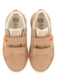 Zapatillas de lona beige con doble correa de Velcro, detalles en naranja y una suela texturada natural. Presentan espuma viscoelástica para mayor comodidad.