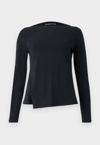 Black long-sleeve top made from smooth fabric, featuring a high neckline and an asymmetric hem with side slits for a modern design.