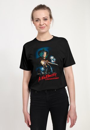Schwarzes T-Shirt mit einem bunten Grafikdesign einer Horrorszene, das das Gesicht eines Charakters zeigt, mit dem Titeltext darunter.