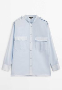 Chemise bleu clair à manches longues, boutonnée, avec deux poches poitrine, des épaulettes et un col mao, posée à plat sur un fond blanc.