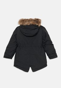 Parka invernale nera con cappuccio rifinito in pelliccia sintetica marrone, maniche lunghe e vita cintrata, vista da dietro su uno sfondo bianco.