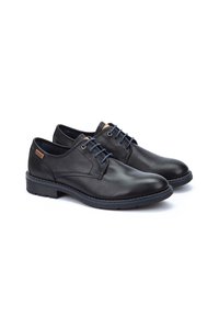 Chaussures en cuir noir avec une texture lisse, bout rond, lacets bleus et un détail de semelle bleue contrastant. Design minimaliste sans motifs.