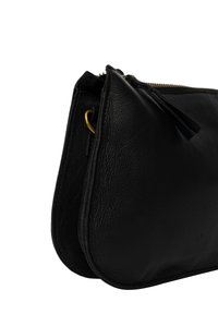 Borsa a pochette in pelle nera con finitura testurizzata, forma curvata, chiusura con zip dorata e un accentuazione con nappina. Fodera interna liscia.