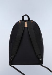 Svart tygryggsäck med två axelremmar. Har en texturerad panel på toppen, slät yta och justerbara remmar.