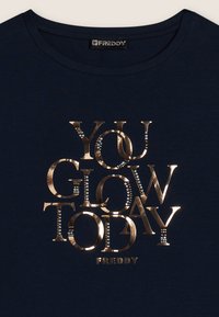 Camiseta de algodón azul marino con texto en dorado metálico "YOU GLOW TODAY" con acentos de pedrería, cuello redondo y mangas cortas.