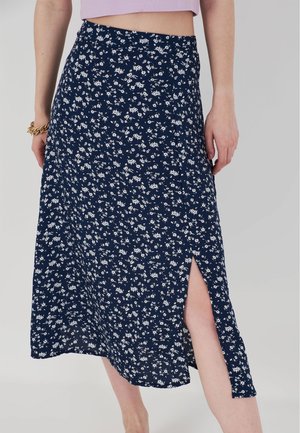 Gonna midi floreale navy in tessuto leggero con uno spacco laterale. Presenta piccoli fiori bianchi su tutta la superficie e una vita aderente.